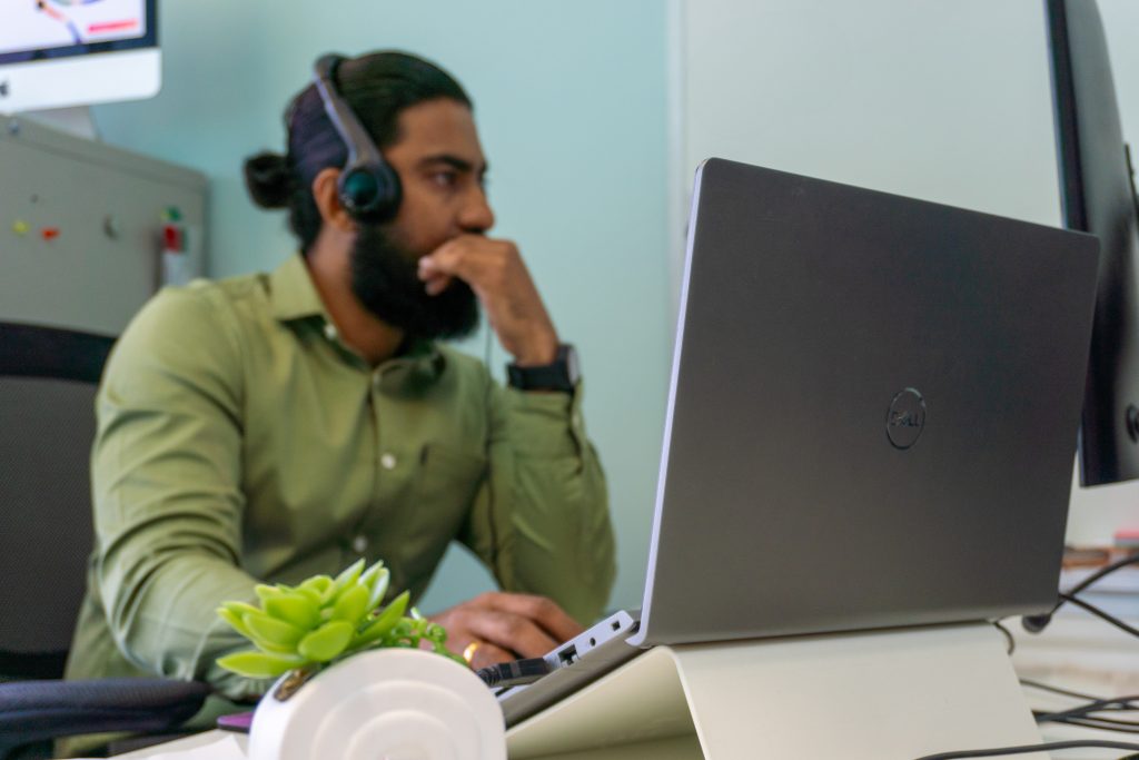 A man working on his laptop with headphones on